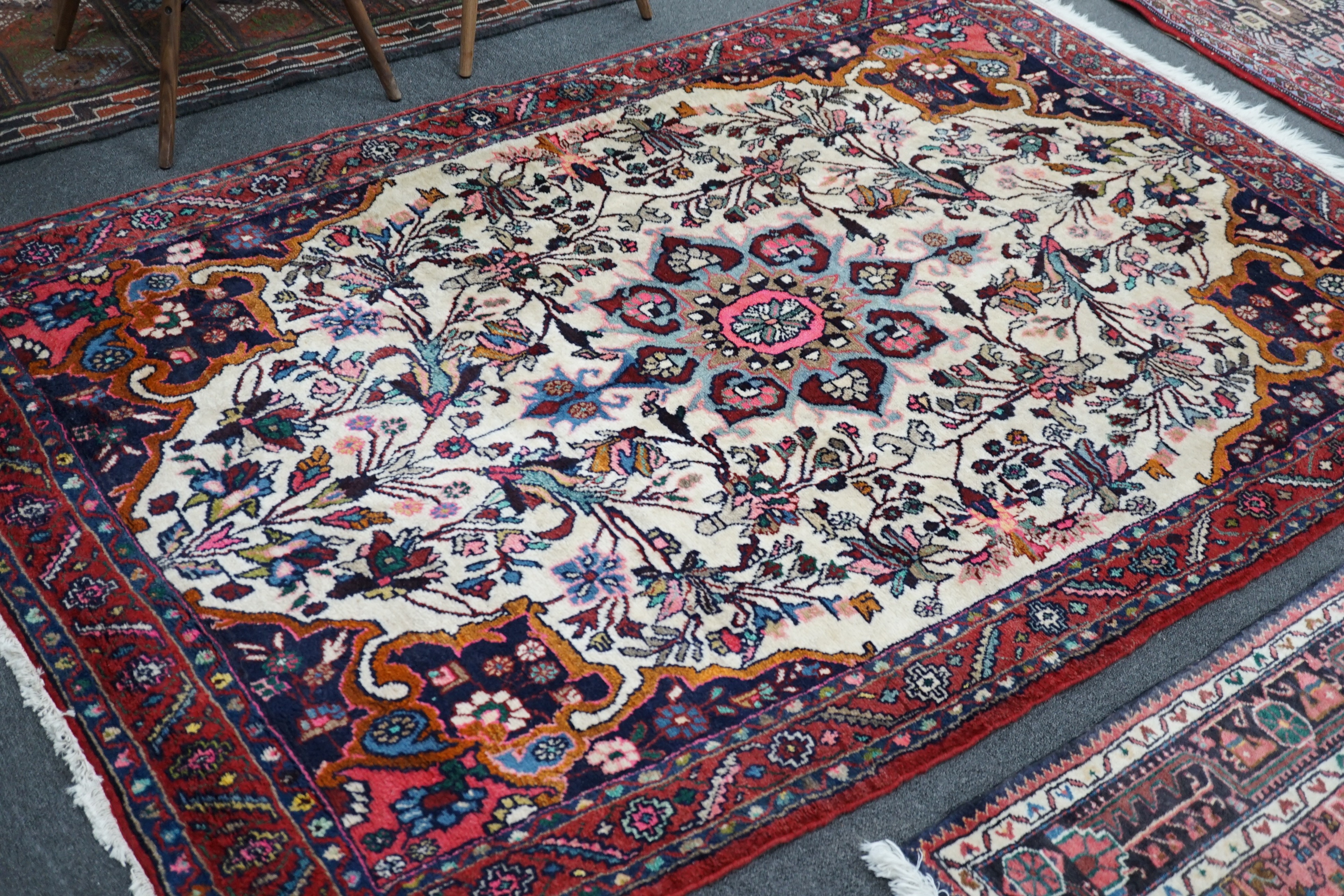 A North West Persian ivory ground rug, 220 x 140cm, and a smaller blue ground rug